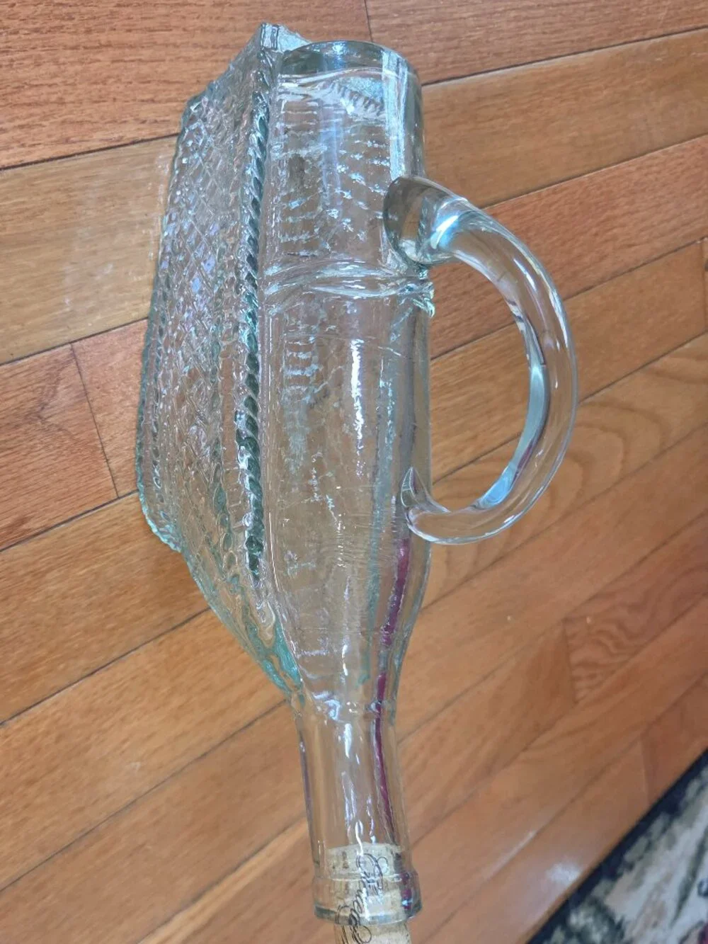 vintage molded clear wine decanter mimics a bottle resting in a basket